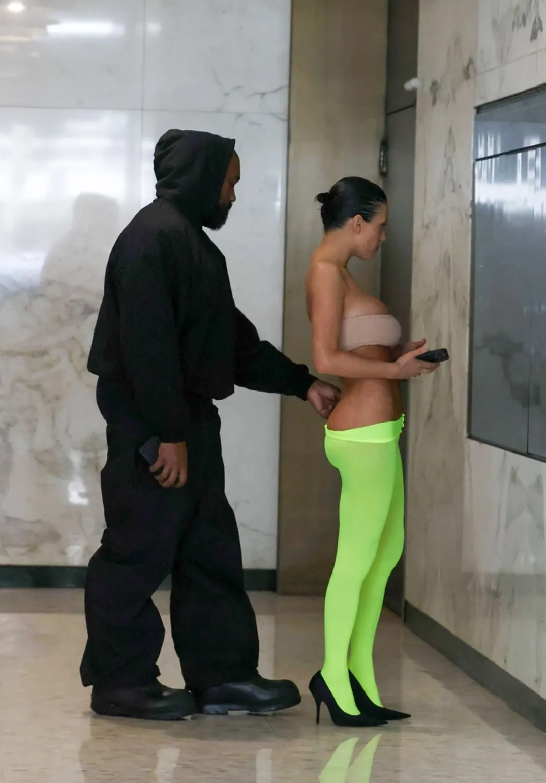 Le rappeur Kanye West baisse le legging de sa femme Bianca Censori pour dévoiler ses fesses alors qu'ils se rendent à une réunion d'affaires (Photos).