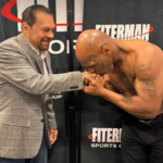 Mike Tyson s'affiche torse nu lors d'une séance de signature d'autographes, montrant son physique musclé.